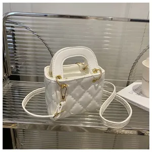 Close-up of white quilted PU leather mini bag with gold hardware and thin crossbody strap