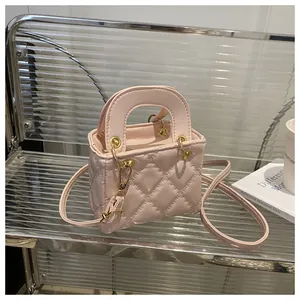 Detail view of pink quilted mini handbag with gold hardware and detachable shoulder strap