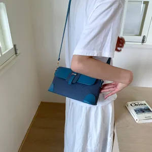 Sac baguette sous l'aisselle bleu avec texture tissée et empiècements en cuir