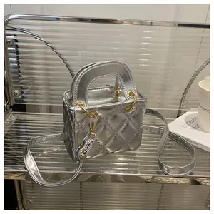 Detail of silver quilted mini handbag showing metallic finish and gold hardware