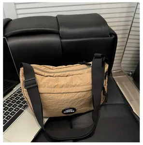 Dettaglio della borsa a mezzaluna in nylon marrone chiaro con cinturino regolabile