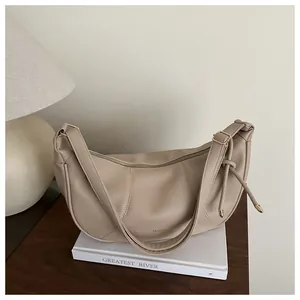 Detail of beige lychee grain leather hobo bag with gold hardware and adjustable strap