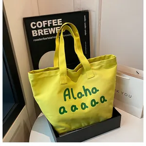 Détail du sac fourre-tout en toile jaune avec imprimé vert et grand compartiment