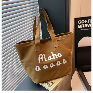 Détail d'un sac cabas en toile marron avec imprimé lettres et larges bandoulières