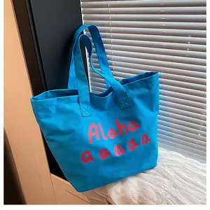 Détail du sac cabas en toile bleu vif avec texte Aloha rose et bandoulières épaisses