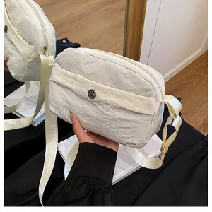 Macro shot of white nylon shoulder bag with crinkled texture and circular metal logo