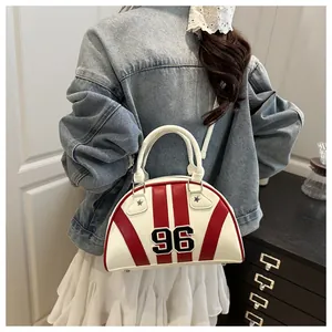 Detail van rood-witte bowlingtas met 96 print gedragen door model in casual stijl