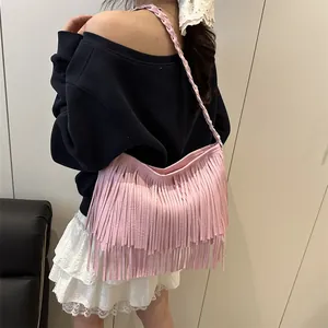 Sac hobo rose chic avec de longues franges et bandoulière tressée sur un mannequin