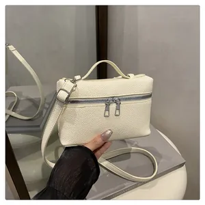 Detail of cream white mini crossbody bag featuring premium lychee grain leather texture