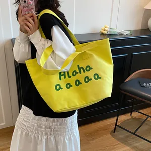 Sac fourre-tout en toile jaune vif avec imprimé vert présenté dans un décor d'intérieur