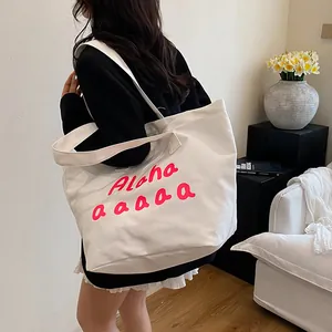 Grand sac fourre-tout en toile blanche avec imprimé Aloha rose dans un décor intérieur