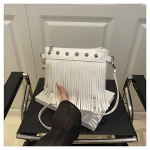 Détail du sac à franges en cuir blanc avec rivets argentés et texture souple
