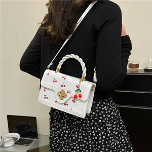 Modern white PU crossbody bag with cherry print, twist handle and cherry charm pendant