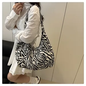 Fashionable zebra print tote bag shown on model with spacious shoulder strap design