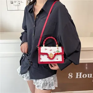 Mini white crossbody bag with red cherry print and floral clasp for summer style