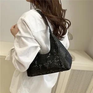 Minimalist black animal texture hobo bag worn as an underarm shoulder bag
