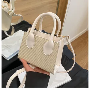Detail of crossbody bag with beige woven straw panel and cream faux leather trim