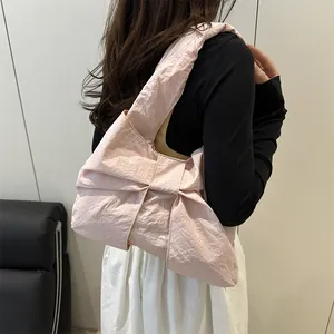 Pink oversized bow tote bag with pleated texture and wide strap on casual outfit