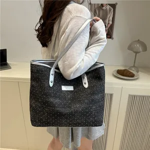 Black polka dot denim tote bag with silver leather straps for stylish daily commuting