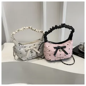 Detail showing white and pink mini handbags with bow textures, charms and metal chains