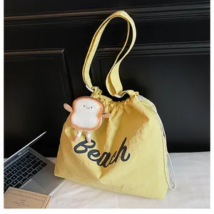 Yellow drawstring tote bag with Beach print and cute toast plush charm detail