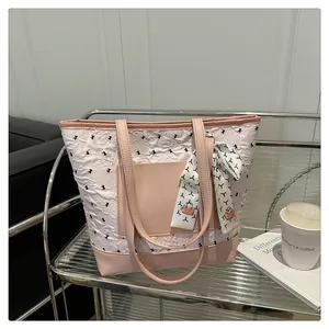 Detailed view of pink tote bag with pleated texture and decorative silk scarf on handle