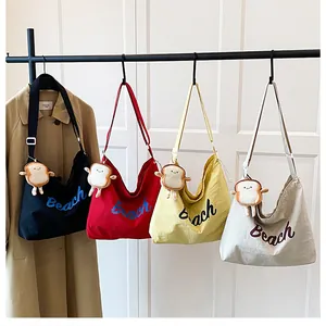 Detail view of four colorful canvas tote bags with Beach embroidery and toast charms