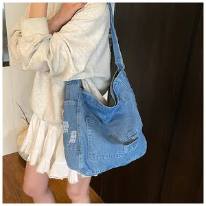 Detailed view of distressed blue washed denim tote bag with multiple patch pockets