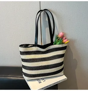 Close-up of woven texture on large striped tote bag with black faux leather straps