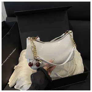 Sac demi-lune blanc brillant avec chaîne dorée et charm cerise en boîte cadeau