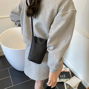 Minimalist black lychee pattern leather bucket bag with slim shoulder strap for daily wear