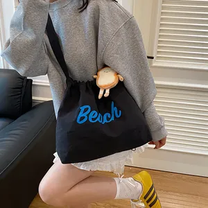 Black canvas tote bag with blue Beach embroidery and cute toast plush charm