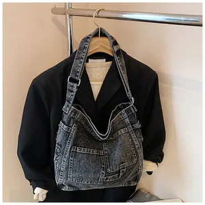 Detail of vintage washed black denim shoulder bag with multi-pocket workwear design