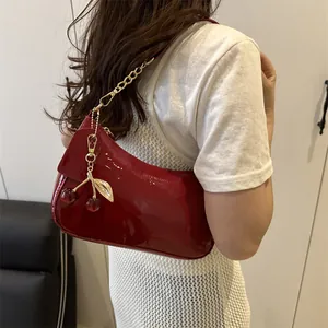 Sac sous le bras rouge verni pour femme avec chaîne dorée et breloque cerise