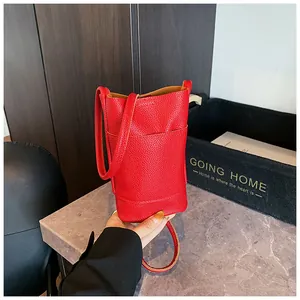 Rote zylindrische Umhängetasche mit Lychee-Textur, Vordertasche und Schultergurt