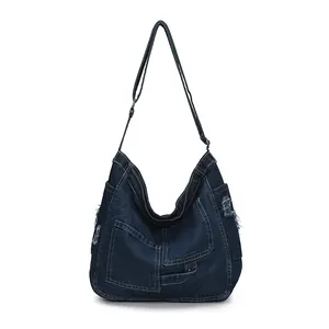 Minimalist deep blue denim crossbody bag with distressed edge details and large capacity