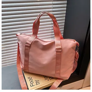 Close-up of pink Oxford cloth travel bag showing reinforced handles and metal buckle details