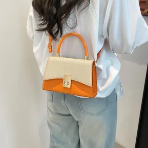 Fashionable bright orange leather and straw patchwork crossbody bag with gold buckle lock