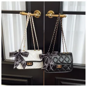 Detail of quilted leather bags with gold hardware and silk ribbons on handles