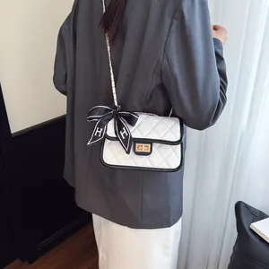 Quilted white crossbody bag with contrast black trim and gold twist lock detail