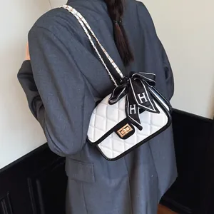 White quilted shoulder bag with black trim and elegant gold square lock for women