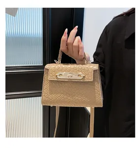 Detailed view of woven texture and golden metal twist lock on beige crossbody bag