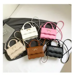 Group view of mini bow crossbody bags in five colors with wavy edges and gold accents