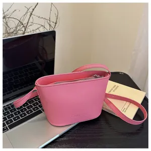 Detailed shot of pink FANYISSA bucket bag on office desk showing smooth PU leather texture