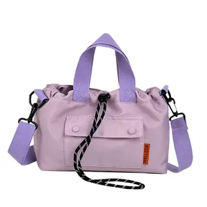 Purple nylon crossbody bag with drawstring closure and contrasting orange side label