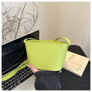 Close-up of lime green mini bucket bag with embossed logo and fine leather texture