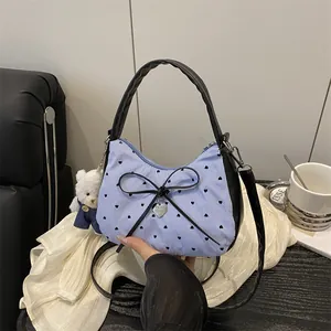 Blue striped shoulder bag with heart prints and a black bow with a bear charm