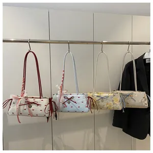 Detail view of canvas underarm bags with lace trims and decorative ribbon bows