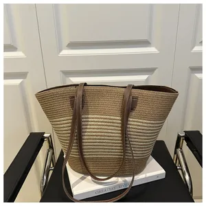 Detail of striped woven tote bag with brown leather straps and contrast stitching texture