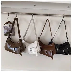 Detail view of retro shoulder bags in dark brown, cream, tan, and black glossy leather